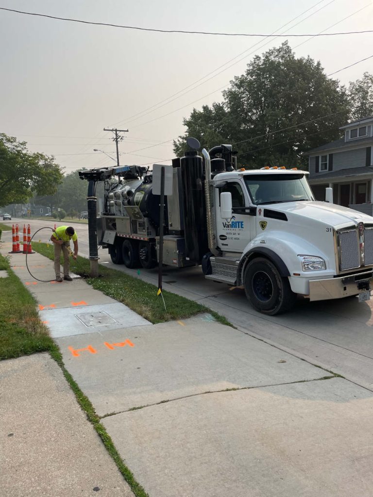 Van Rite Plumbing crew using a hydro excavation truck to expose a buried water line