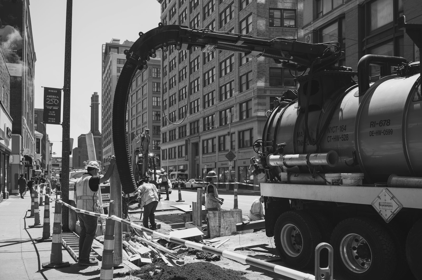hydrovac truck vacuuming soil to expose buried utilities on a city street